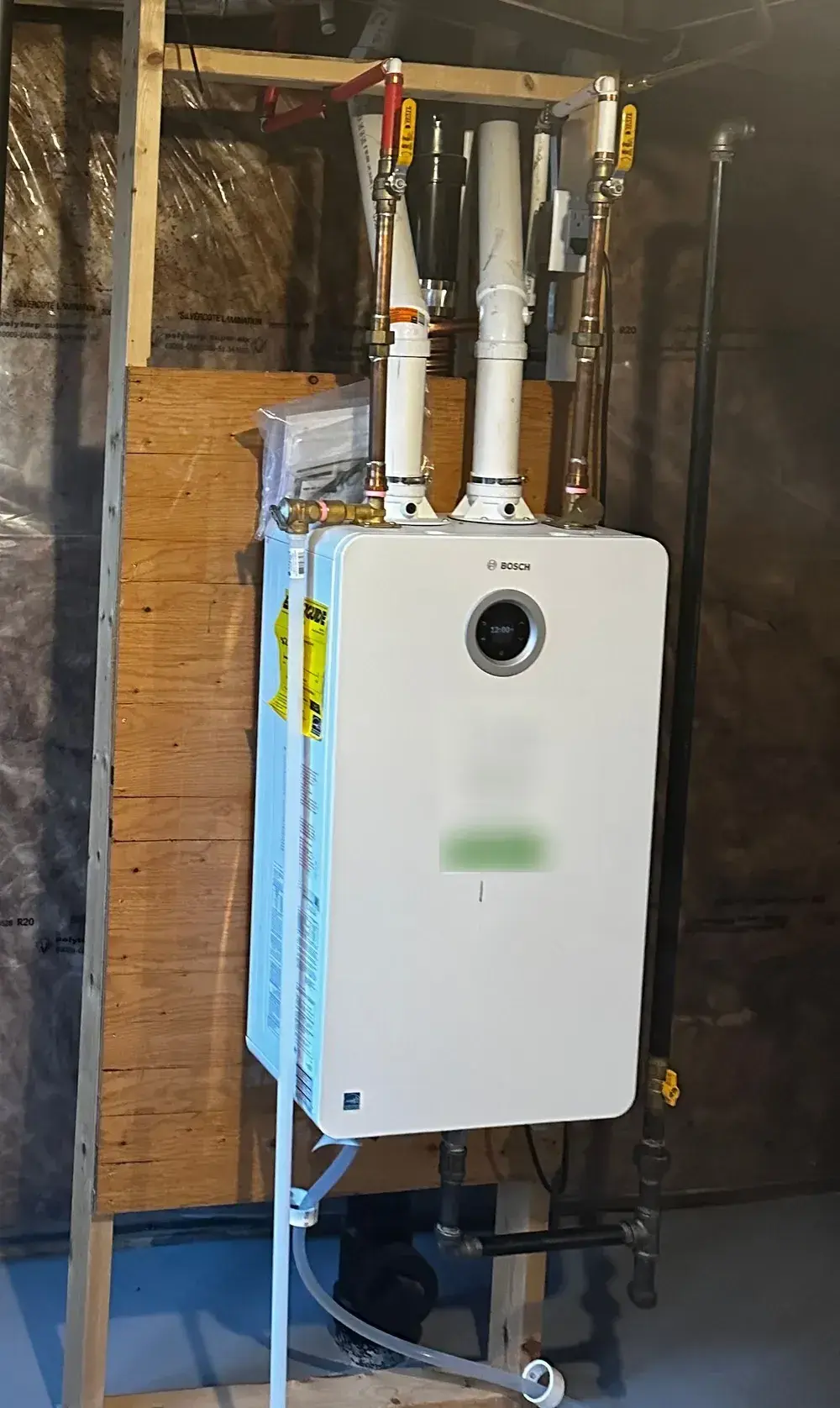 Bosch condensing tankless water heater wall-mounted with PVC venting and copper water lines