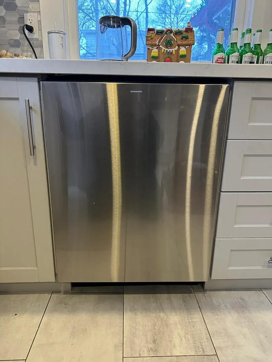 Stainless dishwasher in a white shaker kitchen
