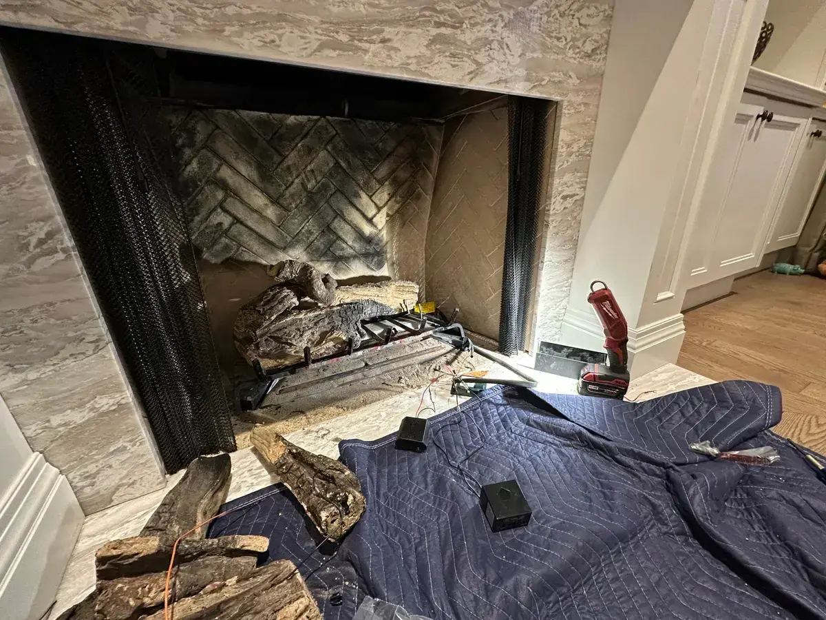 Gas fireplace opened for service with a drop cloth down