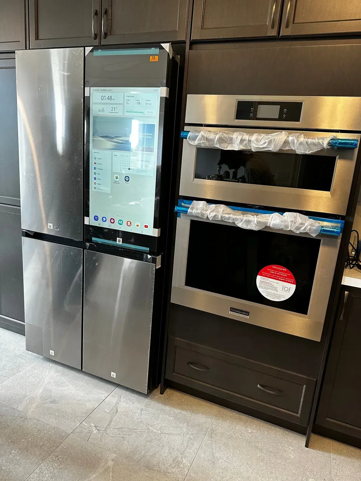 Samsung double wall oven and Family Hub refrigerator installed, protective film still on