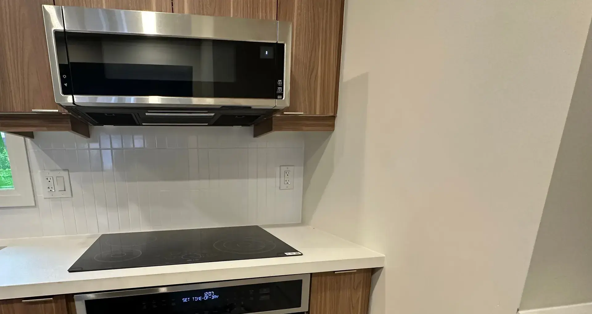 Over-the-range microwave and wall oven installed in walnut cabinetry