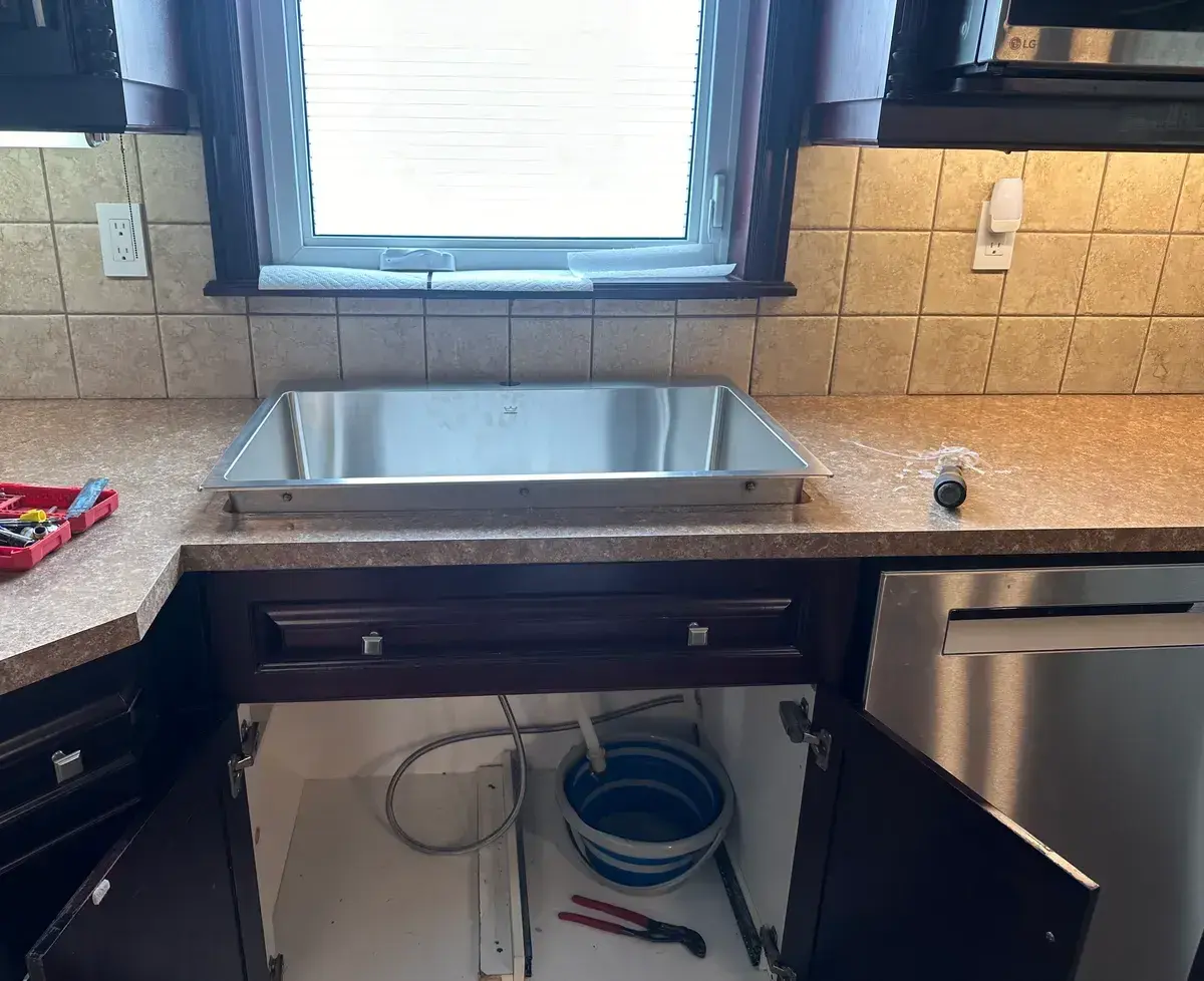 New stainless drop-in sink set into the counter, faucet not yet installed