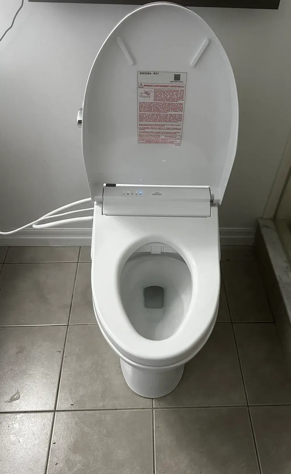 TOTO toilet with Washlet bidet seat installed, control panel illuminated