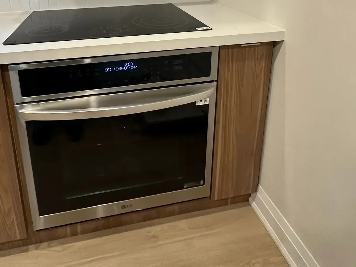 Wall oven and induction cooktop set flush into walnut cabinetry